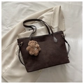 Detail of dark brown matte tote bag with plush bear charm on a beige blazer - With Charm / Brown