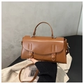 Detailed close-up of brown synthetic leather handbag featuring double buckle decor and silver hardware - Tan