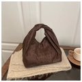 Detailopname van luipaard shopper met geknoopte handgreep op gebreide achtergrond - Bruin