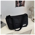 Dettaglio della borsa tote in tela nera con etichetta fashion e tracolla regolabile - Nero