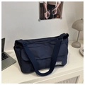 Gros plan d'un sac messager en nylon bleu marine avec une étiquette FASHION grise - Bleu
