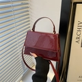 Schicke quadratische Handtasche aus burgunderrotem Lackleder mit Griff und Goldteilen - Rot