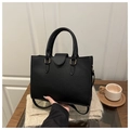 Close-up of black lychee grain leather tote bag with gold hardware and dual handles - Black