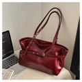 Detailansicht der burgunderroten Lackledertasche mit Metallschnallen und Silberösen - Rot