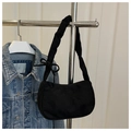 Detail of a black crescent shoulder bag featuring a knotted bow strap and velvet texture - Black