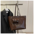 Set borsa tote marrone scuro lucido con pochette coordinata su una gruccia - Marrone
