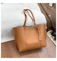 Detailansicht einer hellbraunen Leder-Shopper-Tasche mit langen Riemen auf hellem Dekor - Braun