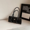Minimalist black leather baguette bag with dual straps and silver twist lock detail - Black