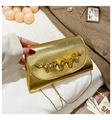 Makro-Detail der goldenen Umhängetasche mit strukturierter Oberfläche und Metalldekor - Gold