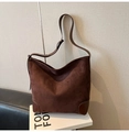 Vue de côté d'un grand sac hobo en daim marron avec des sangles en cuir ajustables - Café sans Pendentif