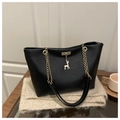 Black pebbled leather tote bag with gold deer charm and chain strap on a cozy scarf - Black