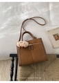 Detail der braunen Vintage-Wildledertasche mit Metallreißverschluss und Plüschtier - Braun mit Anhänger