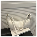 Close-up of white leather crescent hobo bag with tassel detail on a minimal background - White