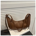 Detail view of brown hobo bag with fringe accents and golden metal logo plate - Brown