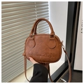 Detail of vintage brown PU leather handbag featuring large embossed letters and gold hardware - Brown