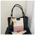 Detalle del bolso tote tricolor con pañuelo de seda sobre un fondo minimalista y limpio - Rosa