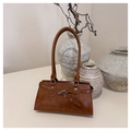 Detail of a brown leather shoulder bag with vintage silver buckle and strap accents - Brown