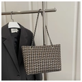 Detalle de textura de bolso tote de tweed a cuadros con cadena de metal sofisticada - Negro