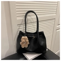 Detailed close-up of a black minimalist tote bag with a brown plush dog charm accessory - With Pendant / Black