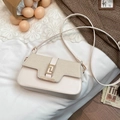 Elegante borsa a tracolla bianco crema con fibbia dorata e trama intrecciata su letto - Bianco