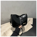 Détail d'un sac bandoulière en cuir verni noir avec surpiqûres blanches et dorées - Noir