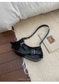 Detail of black glossy leather underarm bag with silver buckles and a bear charm - Black