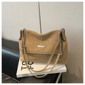 Détail du sac cabas en cuir fauve avec bandoulière chaîne argentée sur un livre - Kaki (Sans Pendentif)