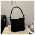 Schwarze Wildleder-Beuteltasche mit Knotengriff und goldenen Details auf einer Strickdecke - Schwarz