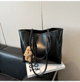 Detail of glossy black oil wax leather tote bag with a cute brown plush bear charm - Black with Pendant