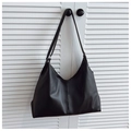 Detalle de bolso tote de cuero negro con costuras verticales y correa fina de hombro - Negro