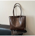 Detail shot of vintage dark brown tote bag resting on a design book for business style - Coffee without Pendant