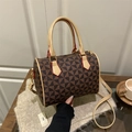 Borsa a mano Boston con motivi geometrici e bordi rossi, mostrata su uno sfondo neutro - Marrone