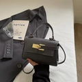 Dark grey pebble leather crossbody bag with light gold hardware on white background - Black
