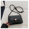 Detail of minimalist black matte leather bag with golden buckle on white fabric - Black