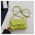 Detail of neon green leather shoulder bag with gold square buckle on white fabric - Green