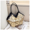 Detailansicht der großen goldfarbenen Pailletten-Tasche mit schwarzem Lederbesatz und V-Öffnung - Gold