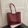 Borsa tote rosso scuro con cuciture geometriche e manici lunghi su sfondo bianco minimale - Rosso