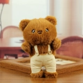 Cute brown plush teddy bear keychain in beige corduroy overalls on a cozy wooden surface - Dark Brown