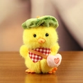 Plush yellow duck keychain with green leaf hat and pink heart bag on wood background - Green Leaf Hat Pink Heart Bag / Yellow