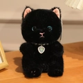 Close-up of black plush cat with blue eyes and heart pendant on a warm wooden surface - About 15cm / Black Cat