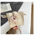 Detail der cremefarbenen Webhandtasche mit Holzknopf, Bärenanhänger und Goldbeschlag - Mit Anhänger / Weiß