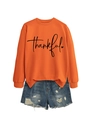 Flat lay of an orange thankful sweatshirt paired with distressed blue denim shorts - Orange (Black Font)