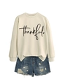 Flat lay of apricot sweatshirt with thankful print and distressed denim shorts - Sand (Black Font)