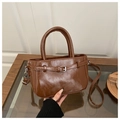 Detalle del bolso retro marrón caramelo con textura brillante y hebilla plateada - Marrón