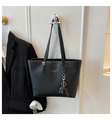 Detail of black leather tote bag featuring gold lettering and small elephant charm pendant - Black