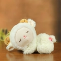 Cute sleeping plush lamb doll in off-white faux fur laying on wooden surface - White Sheep