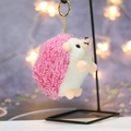 Macro shot of cute plush hedgehog keychain showing soft pink fur and golden metal clasp - Height about 11 / Pink