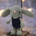 Cute gray plush rabbit keychain in blue corduroy overalls with a warm bokeh background - Gray