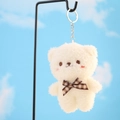Dettaglio portachiavi orsetto di peluche bianco con fiocco a quadri su cielo blu tenue - Bianco