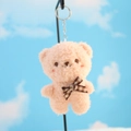 Portachiavi orsetto di peluche rosa con fiocco a quadri marrone su sfondo cielo azzurro - Rosa